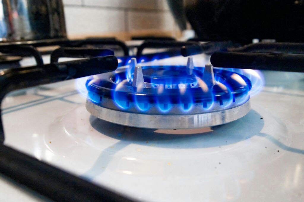 Macro closeup of modern luxury gas stove top with blue fire flame knobs